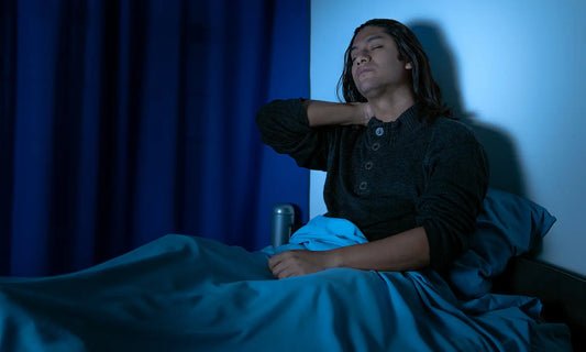 Notebook and glass of water on a bedside table for a busy mind at bedtime wind-down routine