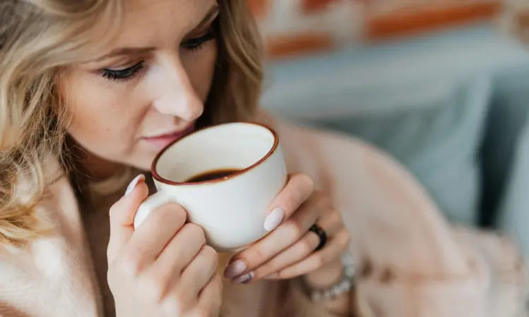 Warm coffee beside cool water and a peach-toned probiotic scoop for the Puraz two-cup morning routine
