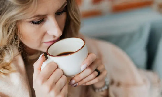 Warm coffee beside cool water and a peach-toned probiotic scoop for the Puraz two-cup morning routine