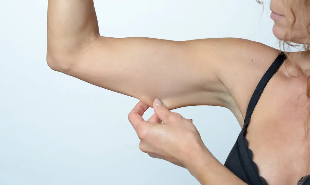 Adult doing strength training after weight loss with healthy food and collagen capsules nearby