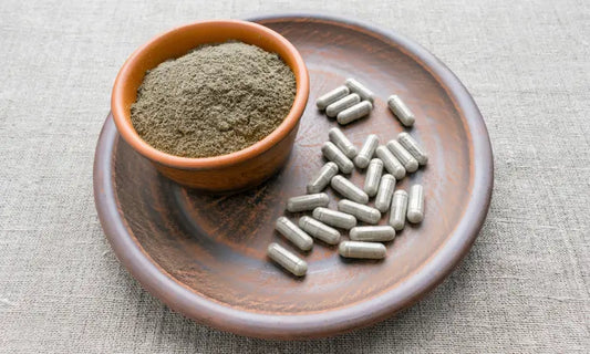Puraz powder scoop and capsule bottle beside water and a travel pouch on a clean kitchen bench