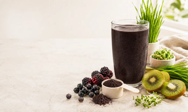 Peach superfood powder smoothie with blackcurrants, boysenberries, kiwifruit, greens and a supplement scoop for a collagen superfood routine