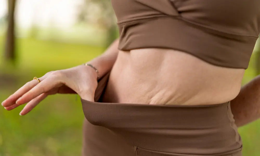 Adult reflecting on loose skin changes after weight loss in a realistic wellness setting